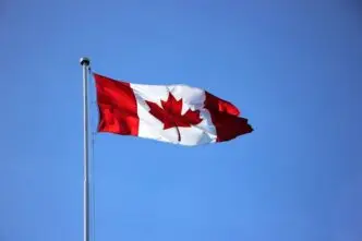 Canadian flag waving proudly against a clear blue sky in Victoria, BC.