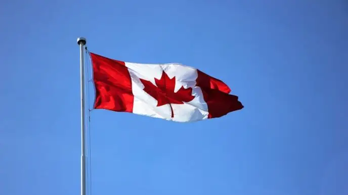 Canadian flag waving proudly against a clear blue sky in Victoria, BC.